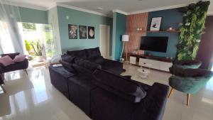 sala de estar con sofá, sillas y TV en Minha Casa na Represa Riviera Santa Cristina II en Itaí