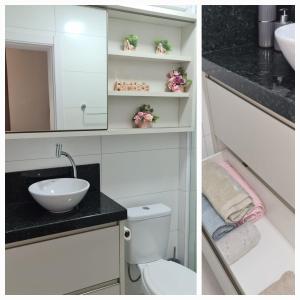 a bathroom with a sink and a toilet and a mirror at Apartamento encantador na praia de Navegantes in Navegantes