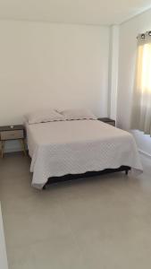 En eller flere senge i et værelse på Apartamento encantador na praia de Navegantes