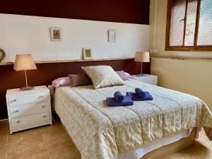 a bedroom with a bed with two towels on it at La Casa Rural de Carlos in Playa de Gandia