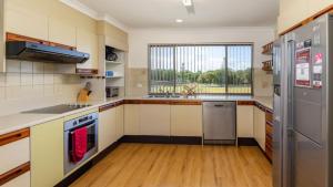 une cuisine avec des placards blancs et une grande fenêtre dans l'établissement Spacious Unit overlooking Moreton Bay - Boyd St, Woorim, à Woorim
