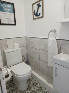 a bathroom with a toilet and a sink at Sunny Beach top apartment 4 in Skegness