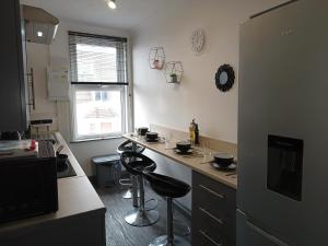 a kitchen with two bar stools and a counter top at Sunny Beach top apartment 4 in Skegness