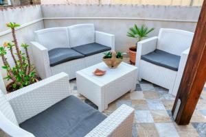a patio with wicker chairs and a table at Daphne B&B in San Vito lo Capo