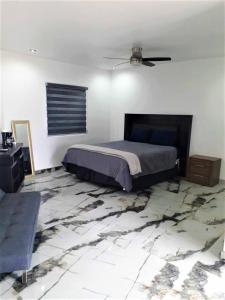 1 dormitorio con 1 cama y ventilador de techo en Santa Fé Apartamentos en Puerto Peñasco