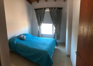 een slaapkamer met een blauw bed en een raam bij Leams in Playa Unión