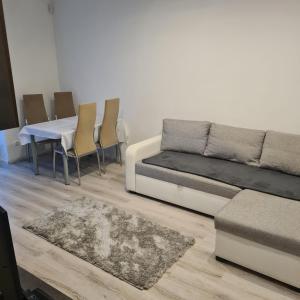 - un salon avec un canapé, une table et des chaises dans l'établissement Verebes apartman, à Győr