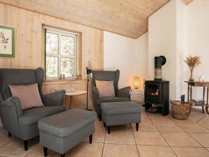 uma sala de estar com duas cadeiras e um fogão em 10 person holiday home in lb k em Skram