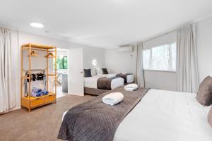 a hotel room with two beds and a window at Acacia Heights - Garden Cottage - Taupo in Taupo