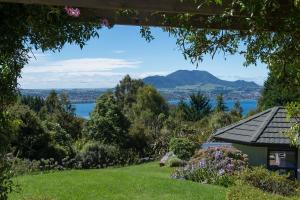 陶波的住宿－Acacia Heights - Garden Cottage - Taupo，从房子的花园中可欣赏到湖景
