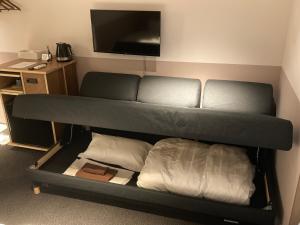 um quarto com um beliche e uma televisão de ecrã plano em Hotel Asakusa KANNONURA em Tóquio