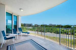 a balcony with chairs and a view of the city at Palms Resort #2416 Full 2 Bedroom in Destin