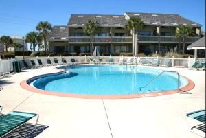een groot zwembad met stoelen en een gebouw bij Seascape Lakefront Villas 281- Family Tides in Destin