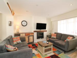een woonkamer met 2 banken en een flatscreen-tv bij Anchor Cottage in Weymouth