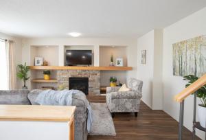 a living room with a couch and a fireplace at Elegant 6 Bedroom House Near U of Manitoba in Winnipeg