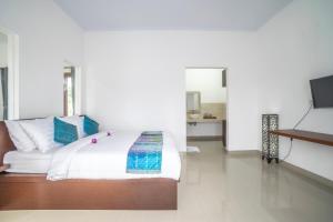 a bedroom with a bed and a flat screen tv at Umah Odah Homestay in Ubud