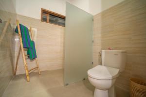 a bathroom with a toilet and a towel rack at Umah Odah Homestay in Ubud +21 photos