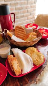 a table with a plate of food and a basket of bread at Chalé Formoso - Chalé Romântico com Hidromassagem in Serra de São Bento