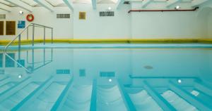 an indoor swimming pool with blue water at Camino Real Aeropuerto in Mexico City