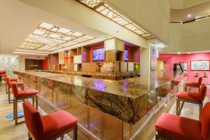 a large bar in a room with red chairs at Camino Real Aeropuerto in Mexico City