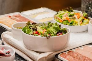 a table topped with bowls of salad and other foods at Camino Real Aeropuerto in Mexico City