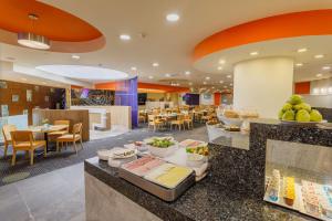 a restaurant with food on a counter with tables and chairs at Camino Real Aeropuerto in Mexico City