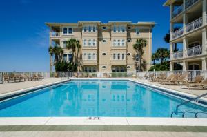 a swimming pool in front of a building at Sunset Serenade in Rosemary Beach