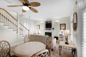 sala de estar con ventilador de techo y mesa en Sunset Serenade, en Rosemary Beach