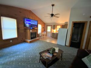 a living room with a flat screen tv on the wall at Cedar Creek Cabins #1 - Giant Spa Tub, Large Wooded Porch, Full Kitchen, 1 Bedroom in Eureka Springs