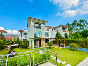ein großes Haus mit einem Zaun davor in der Unterkunft Shaoguan Nanhuasi Jianyi Vacation Villa in Shaoguan