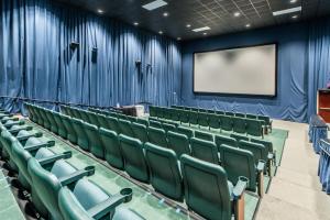 um auditório vazio com cadeiras verdes e um ecrã em Majestic Beach Towers 1-1710 em Panama City Beach