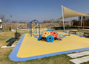 a park with a playground with a slide and a play structure at Confortable casa para descanso de fin de semana in Tlayecac