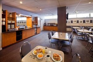 un comedor con mesas y sillas y una cafetería en Hotel les Suites Labelle en Montreal