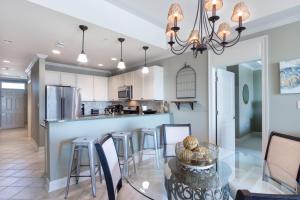 a dining room and kitchen with a glass table and chairs at The Whart Unit 505 condo in Orange Beach