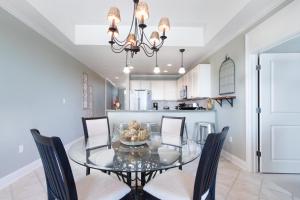 a dining room with a glass table and chairs at The Whart Unit 505 condo in Orange Beach