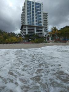 a view of a beach with a tall building at Lindo Apartamento con Wifi in San Carlos