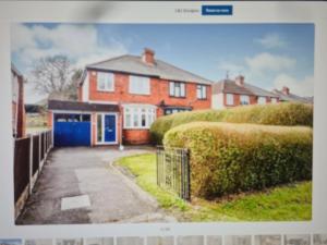 ein Bild eines Hauses mit blauer Garage in der Unterkunft L & J ESCAPES- 4 BEDROOMs SUITABLE FOR CONTRACTORS AND FAMILIES- LARGE PRIVATE PARKING-10 MINUTES TO M6 JUNCTION 9 in Coseley