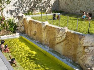 a pool of water with people swimming in it at Okinawa Hinode Resort and Hot Spring Hotel in Naha