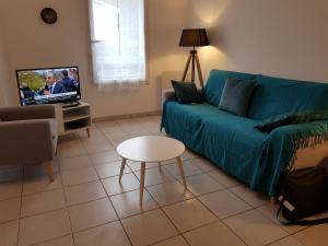 歐當日的住宿－L'océan，带沙发、桌子和电视的客厅