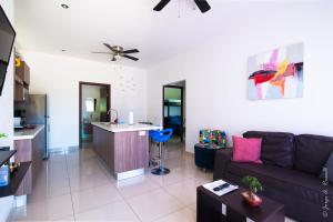 a living room with a couch and a kitchen at Jaco Modern & Beach Apartment - Lapa Living A1 in Jacó