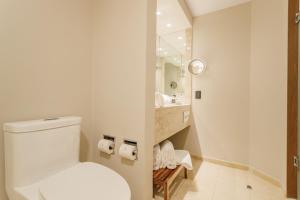 a white bathroom with a toilet and a sink at Camino Real Aeropuerto in Mexico City