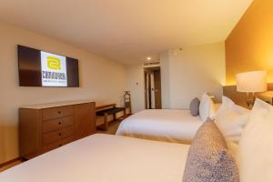 a hotel room with two beds and a tv at Camino Real Aeropuerto in Mexico City