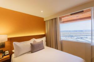 a hotel room with a bed and a window at Camino Real Aeropuerto in Mexico City