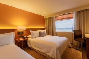 a hotel room with two beds and a window at Camino Real Aeropuerto in Mexico City
