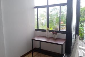 a small table in a room with a window at Gorland Hostel near GOR Satria Purwokerto Mitra RedDoorz in Purwokerto