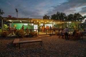 Green Hills Accommodation Village في بورت مورسبي: مجموعة من الناس يجلسون في مطعم في الليل