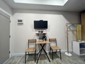 a room with a table and two chairs and a tv at 243Hotel in Ta Phraya