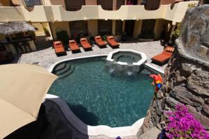 a pool in a hotel with chairs and an umbrella at Vista Hermosa Resort and Spa in Rosarito