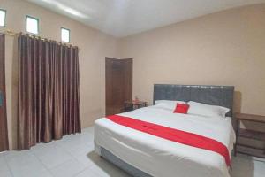 1 dormitorio con 1 cama grande con manta roja en RedDoorz @ Waena Jayapura en Sentani