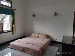a bedroom with a bed in the corner of a room at Kelana 1 Luxury Homestay Semarang, 3 bedrooms in Semarang